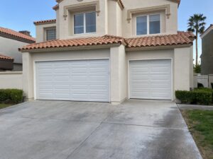 Two newly installed white paneled garage doors on a residential home by Legacy ODS Garage Door Services in Las Vegas, NV.