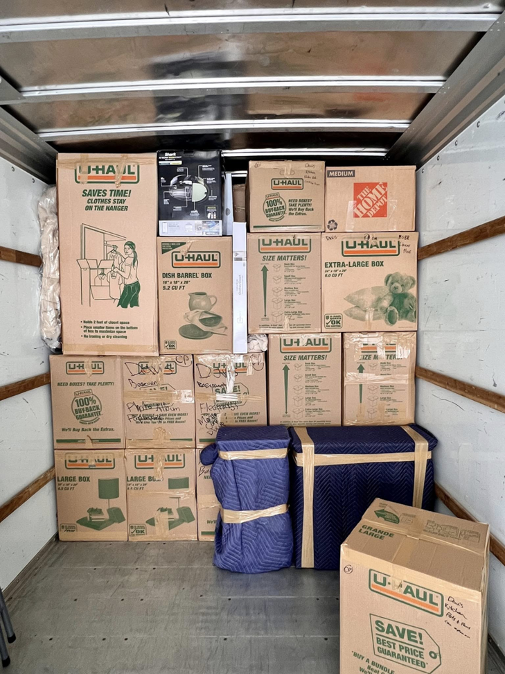 A U-Haul truck packed with moving boxes and furniture pads by Move Moore in Grand Rapids, MI.