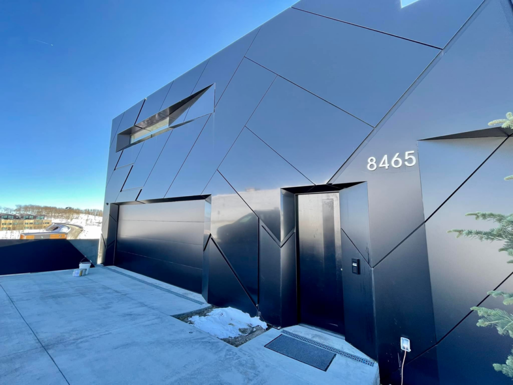 A unique black paneled garage door on a modern geometric home, installed by Windsor Door Sales Inc. in Ogden, UT.