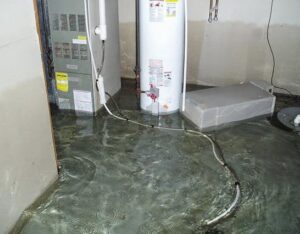 A utility room with a water heater and furnace surrounded by standing water, showing significant water damage in Oakland, CA by One Call Services of Oakland.