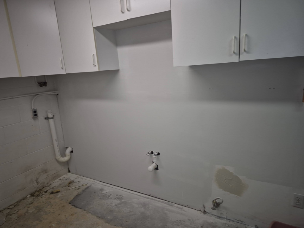 Utility room water damage restoration, exposed concrete floor, plumbing by Risen Handyman services LLC, Council Bluffs, IA.