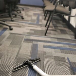 A vacuum cleaner head on a patterned carpet, ready for cleaning by Rubber Gloves Residential Cleaning in San Antonio, TX.