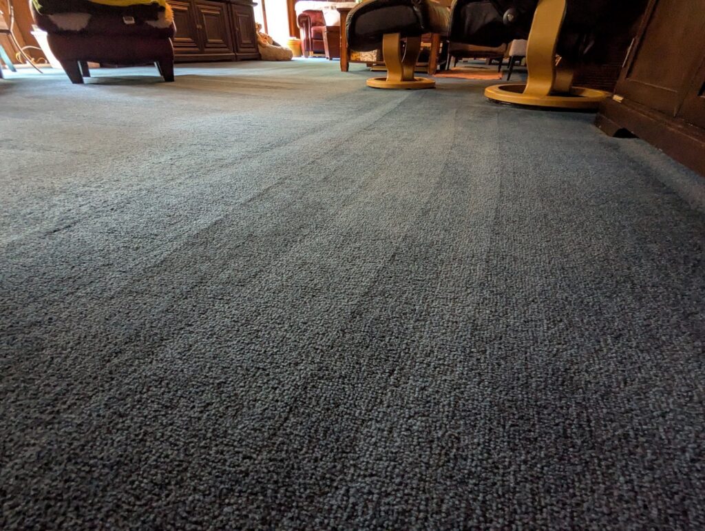 A close-up of a blue carpet showing clear vacuum lines, demonstrating professional floor cleaning by Chelle's Cleaning Services in Gary, IN.