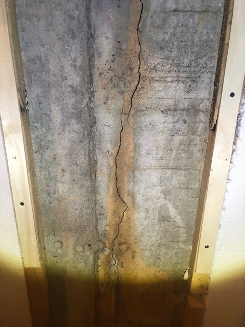 A vertical foundation crack visible on a concrete wall, a common issue addressed by Northeast Wisconsin Waterproofing, LLC in Green Bay, WI.