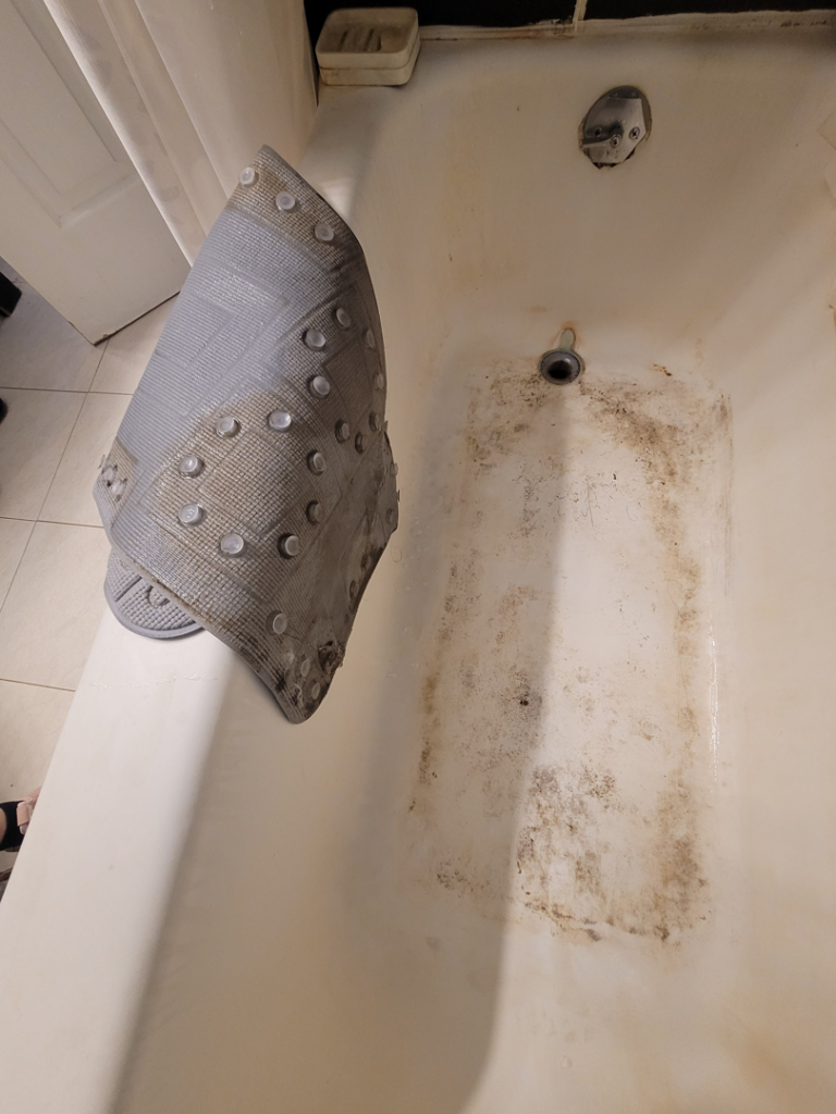 A very dirty bathtub showing grime and stains before cleaning by Ready.Set.Clean LLC in Morley, MI.