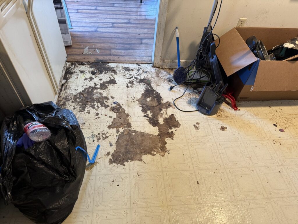 A very dirty kitchen floor with trash and debris before a deep cleaning by Rebeccas Customized Cleaning LLC in Reading, PA.