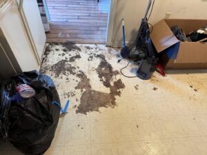 A very dirty kitchen floor with trash and debris before a deep cleaning by Rebeccas Customized Cleaning LLC in Reading, PA.