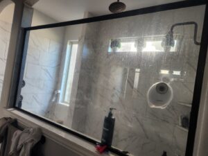 A very dirty shower glass panel covered in soap scum and water stains, ready for cleaning by Rita's cleaning in Fort Worth, TX.