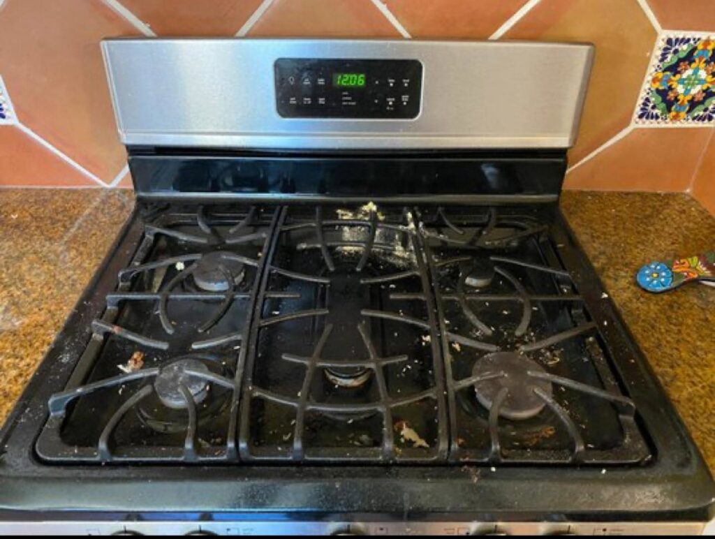 A very dirty stovetop covered in food debris and grease, awaiting cleaning by Best Bay Area Cleaners in Oakland, CA.