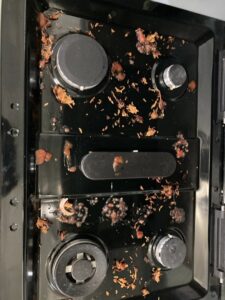 A very dirty stovetop covered in food debris and grease, ready for cleaning by G & S Cleaning Services in Somerville, NJ.