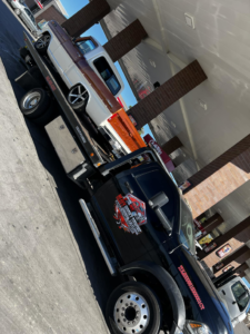 A vintage-style pickup truck being transported on a flatbed tow truck by Heavy Hookz Towing in Fort Worth, TX.