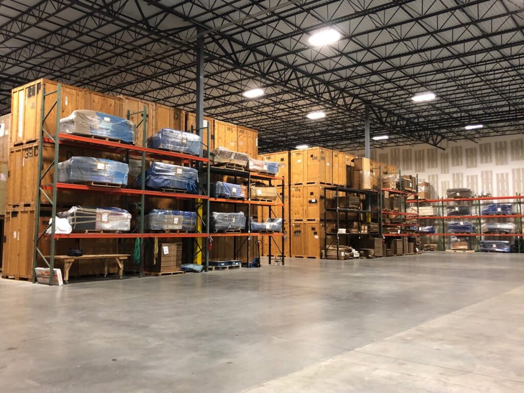 Interior view of a warehouse with numerous wooden storage crates and shelves, part of Capital Relocation Group's services in Raleigh, NC.