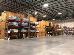 Interior view of a warehouse with numerous wooden storage crates and shelves, part of Capital Relocation Group's services in Raleigh, NC.
