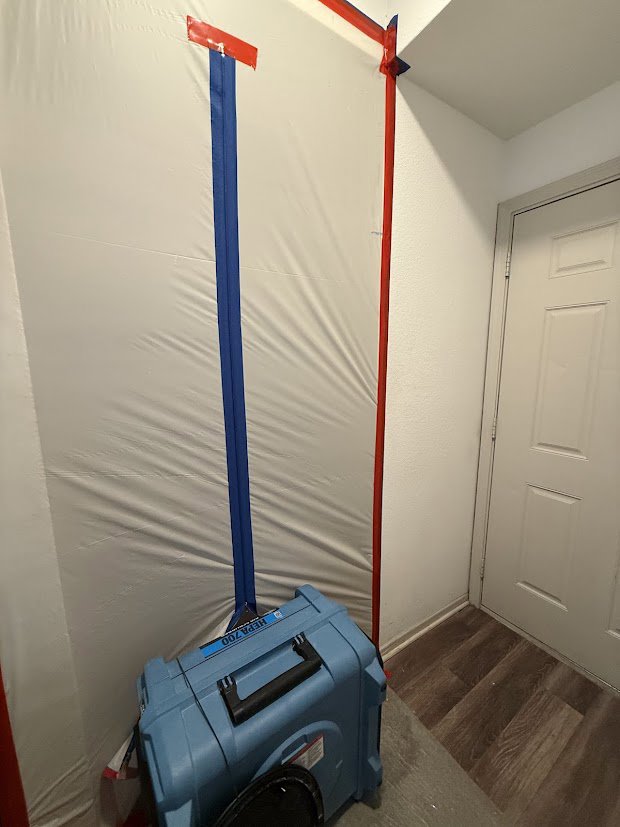 An air scrubber and containment barrier set up for water damage remediation by Flow State Restoration in Gilbert, AZ