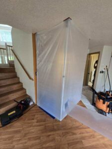 A room with plastic containment barriers and cleanup equipment during water damage restoration by Harbaugh Restoration in Vancouver, WA.