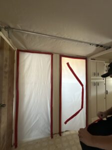 Room with plastic sheeting creating a containment area for water damage or mold remediation by Brothers Restoration in Post Falls, ID.