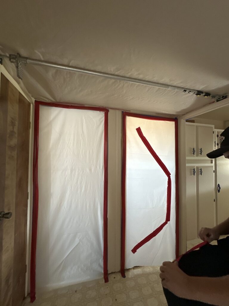Room with plastic sheeting creating a containment area for water damage or mold remediation by Brothers Restoration in Post Falls, ID.