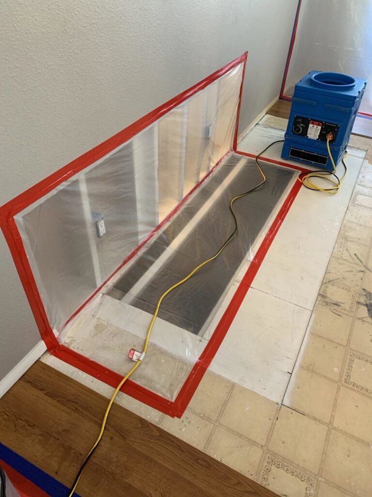 A water damage containment area with plastic sheeting and drying equipment set up by Emergency Flood Team in Gilbert, AZ
