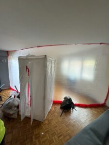 A room with plastic containment barriers set up for water damage remediation by RestoPros of Hartford in West Hartford, CT.