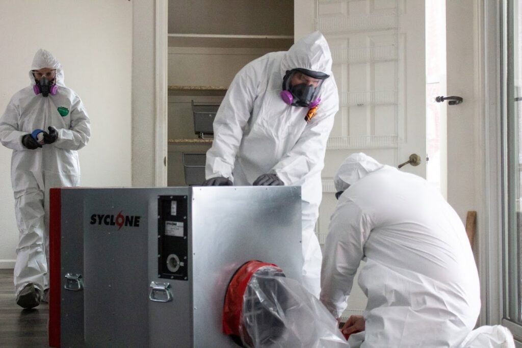 A Pure Restore crew in hazmat suits operating a large industrial dehumidifier in Northglenn, CO.