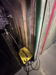 A room with plastic containment and drying equipment for water damage restoration by Harbaugh Restoration in Vancouver, WA.