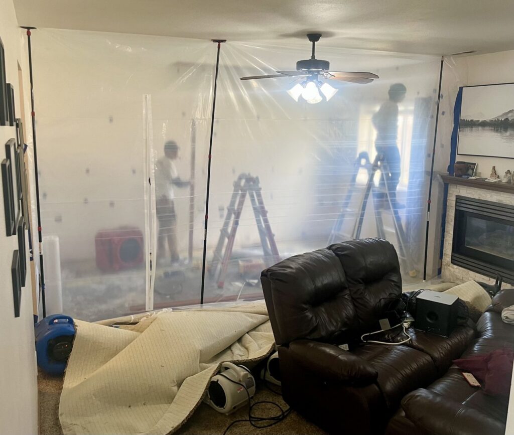 Rainbow Restoration of Meridian technicians setting up plastic containment and air movers for water damage drying in a home in Meridian, ID.