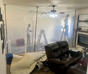 Rainbow Restoration of Meridian technicians setting up plastic containment and air movers for water damage drying in a home in Meridian, ID.