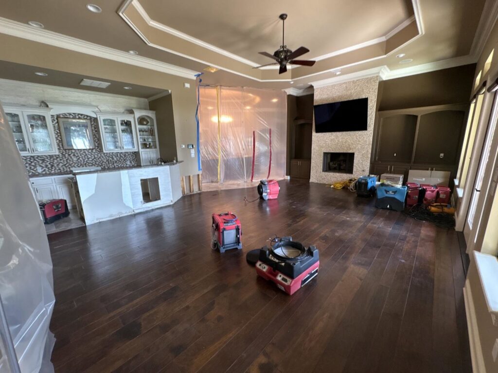 Water damage drying equipment and plastic containment set up in a large room by Restoration Xperts Emergency 24/7 in Deerfield Beach, FL.