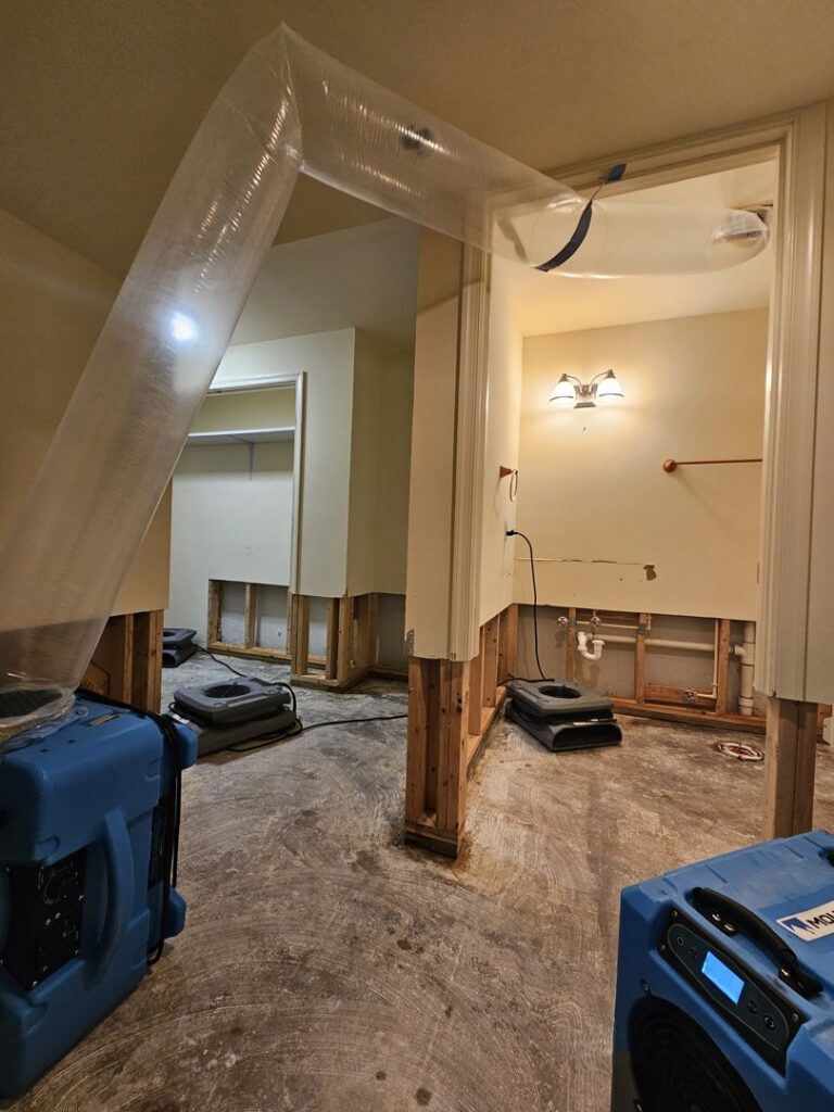 A room undergoing water damage drying with air movers and flexible ductwork by Remont Restoration in Hagerstown, MD.