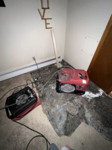 Industrial air movers and a dehumidifier drying a water-damaged floor by All Dry Services of Southern Maine in South Portland, ME.