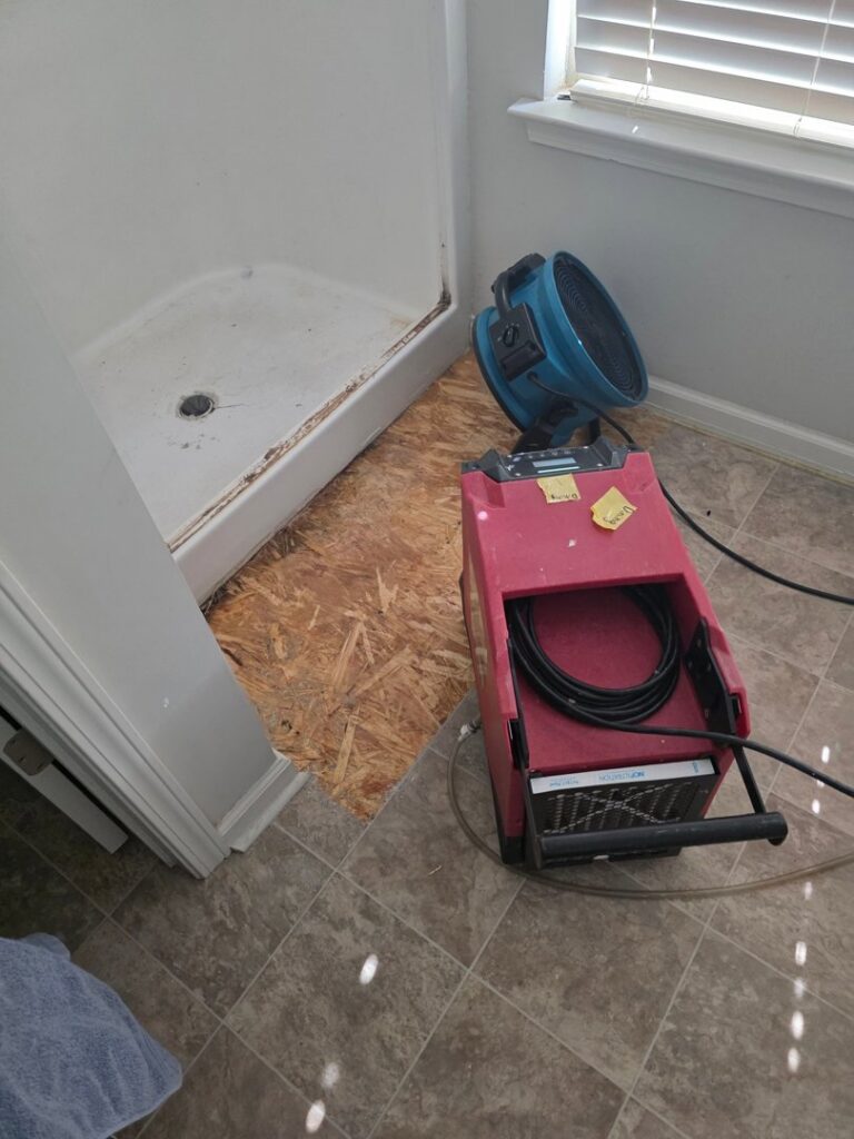 Water damage drying equipment, including a dehumidifier and air mover, in a bathroom by Restoration Specialist in O Fallon, MO.