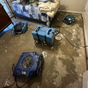 Industrial air movers and dehumidifiers drying a water-damaged bedroom floor, handled by Level Creek Property Restoration in Buford, GA.