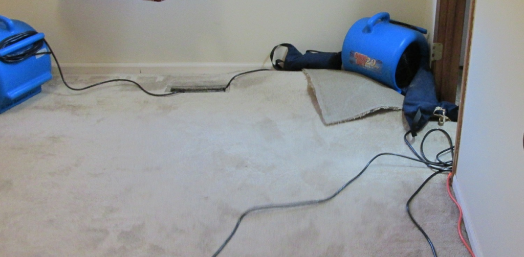 Industrial drying equipment and fans used for water damage restoration on a carpeted floor by AllStar Response in Manhattan, KS