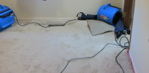 Industrial drying equipment and fans used for water damage restoration on a carpeted floor by AllStar Response in Manhattan, KS