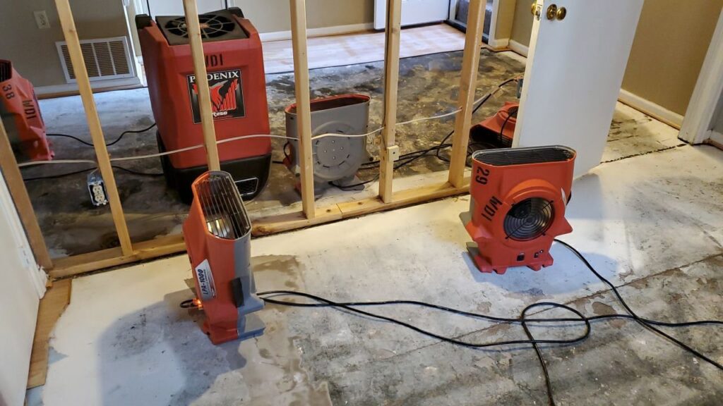 Water damage drying equipment and exposed studs in a room undergoing restoration by Water Damage, Inc. in Denver, CO.