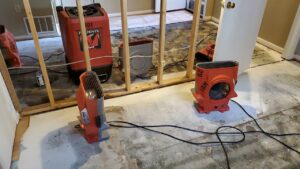 Water damage drying equipment and exposed studs in a room undergoing restoration by Water Damage, Inc. in Denver, CO.