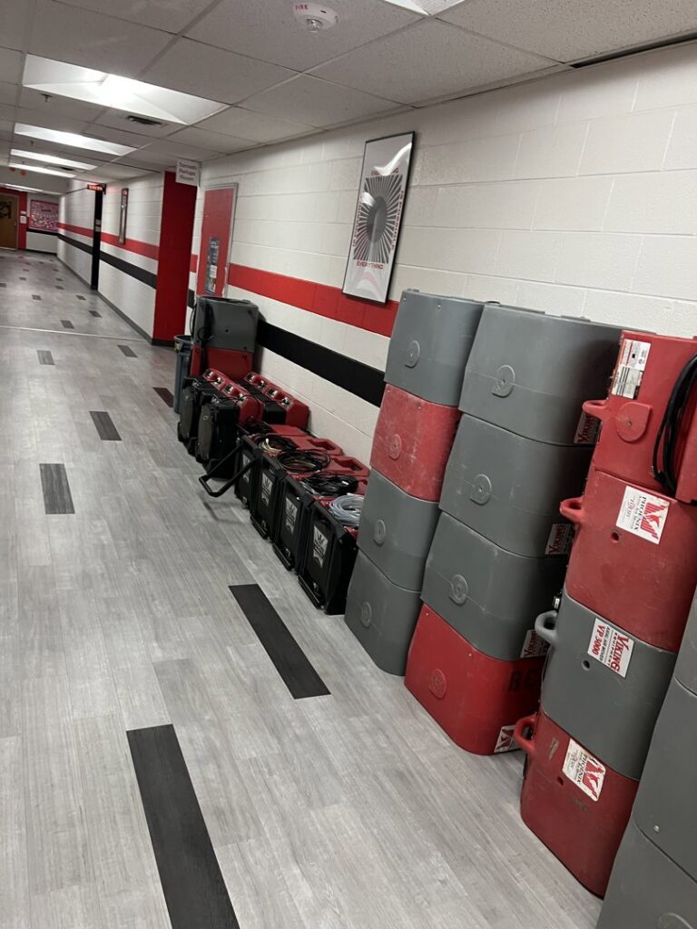 Industrial drying equipment and air movers deployed in a hallway for water damage restoration by Express Restoration in Edmond, OK.