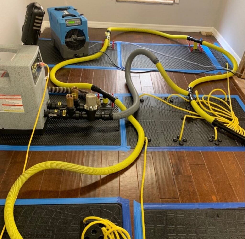 Restored Air water damage drying equipment, including air movers and dehumidifiers, set up on a hardwood floor in Summerville, SC.