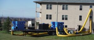 Large water damage drying equipment with yellow ducts leading into a house by Dayspring Restoration in Butte, MT