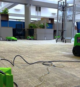 SERVPRO air movers and dehumidifiers set up on a carpeted office floor for water damage drying and restoration in Alexandria, LA.