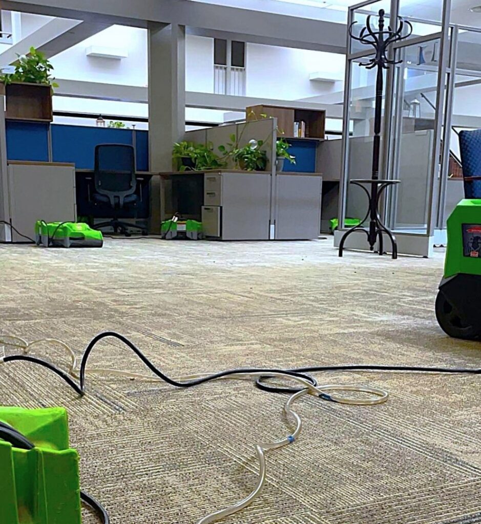 SERVPRO air movers and dehumidifiers set up on a carpeted office floor for water damage drying and restoration in Alexandria, LA.