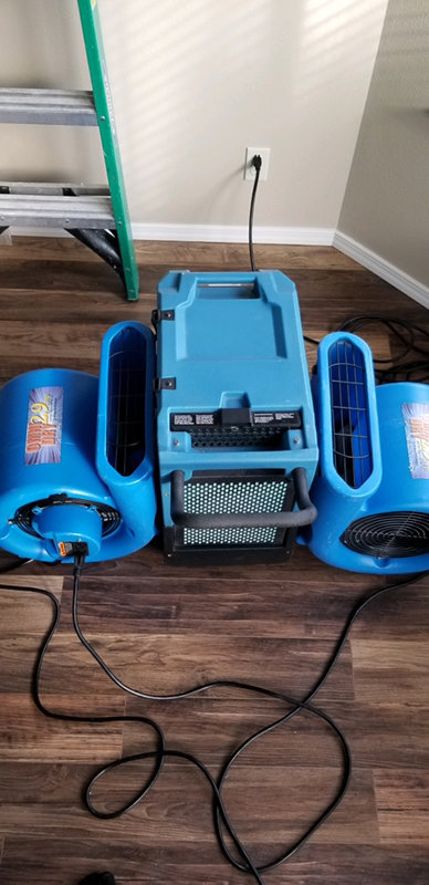 Water damage drying equipment, including air movers and a dehumidifier, in use at a job site by Rainbow International of Coeur D'alene in Post Falls, ID