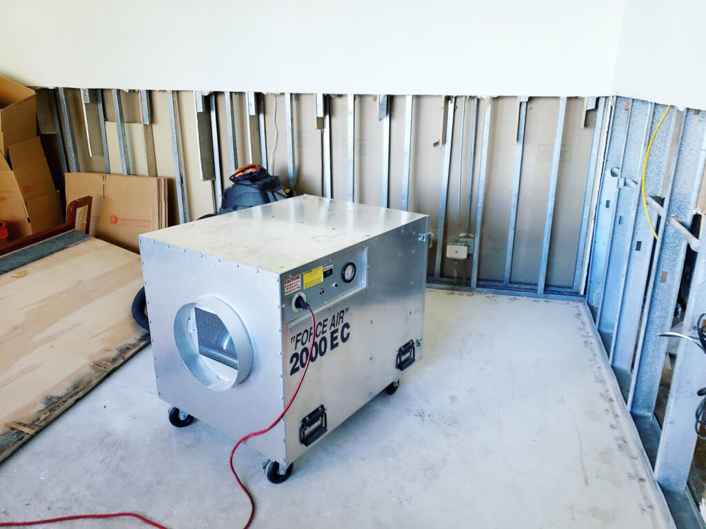 An air scrubber and exposed wall studs indicate water damage drying in progress by Island Restoration LLC in Kapolei, HI.