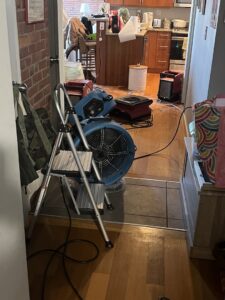 Air movers and dehumidifier drying a kitchen after water damage. Paul Davis Restoration, Belmont, MA.