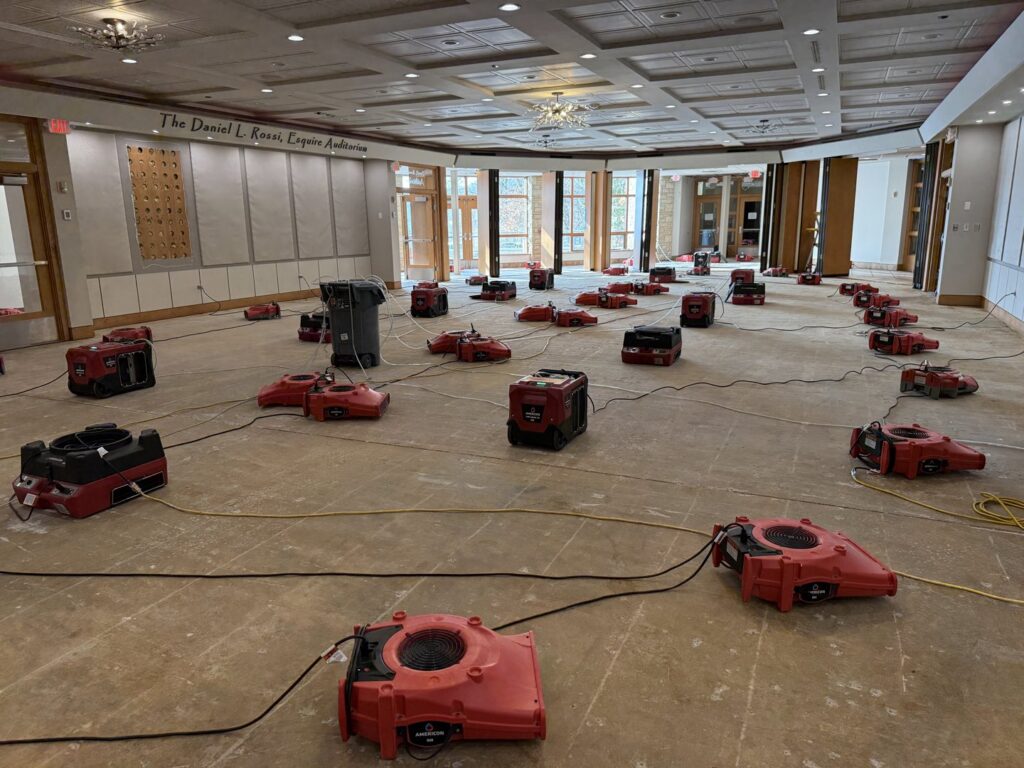 A large room filled with red air movers and drying equipment for water damage restoration by Americon Restoration in Youngstown, OH.