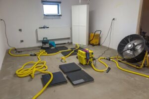 A room filled with professional water damage drying equipment, including fans and dehumidifiers, used by Star Water Damage Fresno, CA.