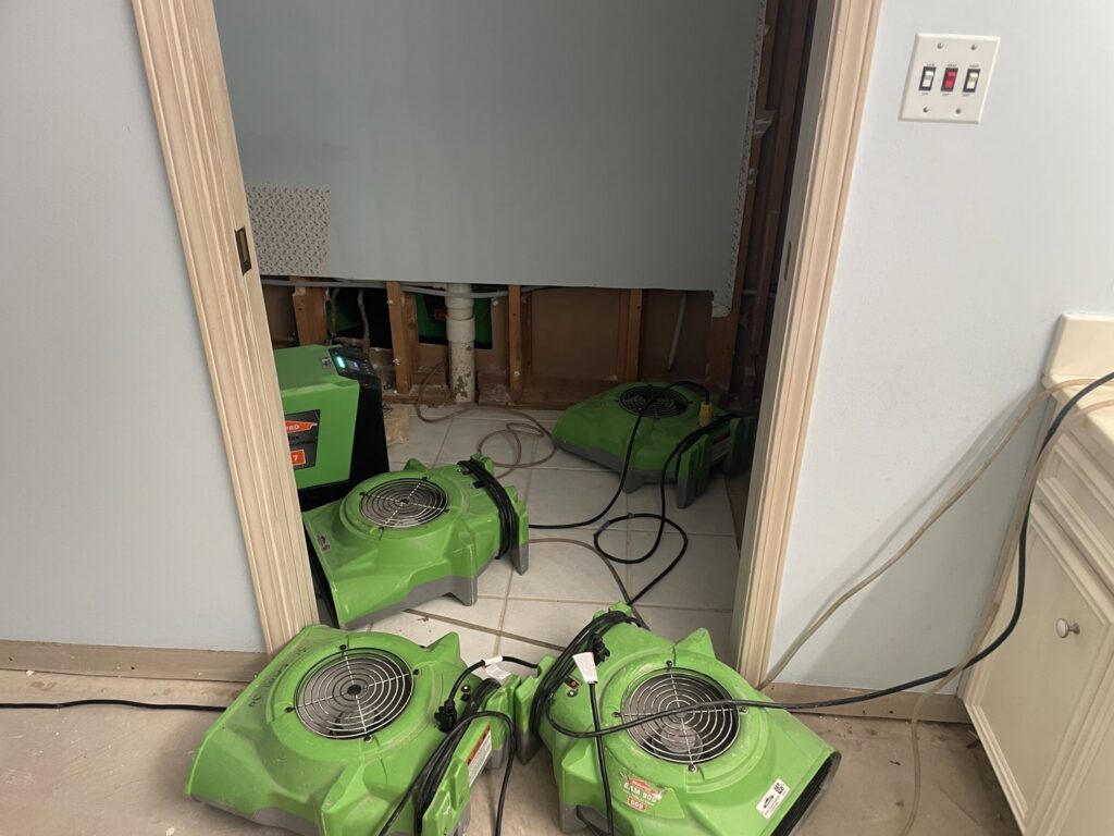 Multiple air movers and dehumidifiers drying a room with exposed wall studs after water damage, by SERVPRO of South Shreveport in Shreveport, LA.