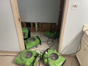Multiple air movers and dehumidifiers drying a room with exposed wall studs after water damage, by SERVPRO of South Shreveport in Shreveport, LA.