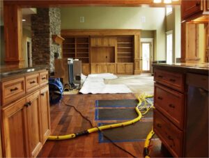Water damage drying equipment, including air movers and drying mats, set up on a wooden floor by Certified Restoration in San Diego, CA