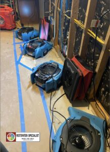 Multiple air movers and drying equipment set up in a room for water damage restoration by Restoration Specialist in O Fallon, MO.